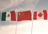 Three flags flying against a sky of Canada, China and Mexico.  
