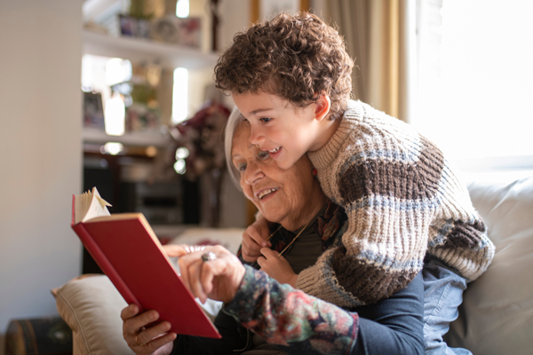 Photo of a grandmother and grandson reading a book together.